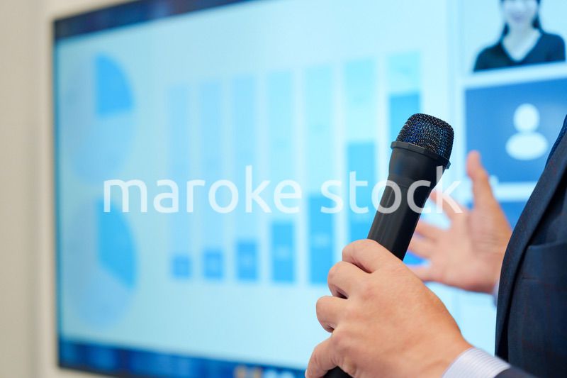 データを示しながらプレゼンをするビジネスマン