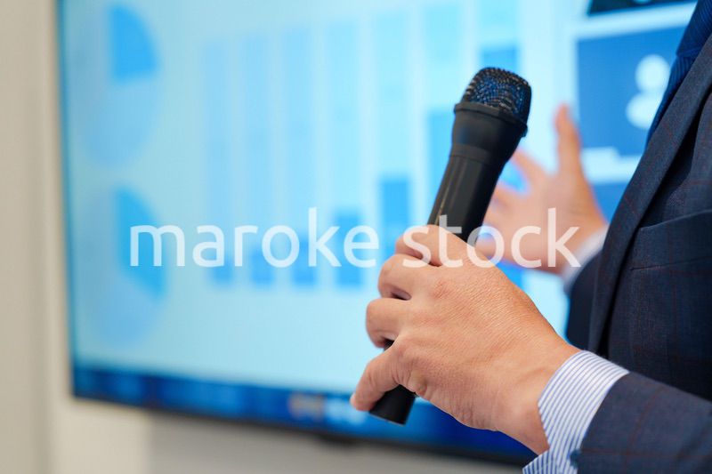 データを示しながらプレゼンをするビジネスマン