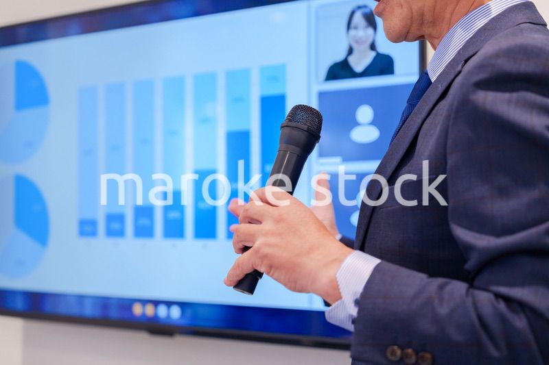 会議で資料を見ながらプレゼンをする中年のオフィスワーカー