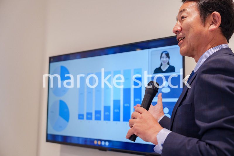 会議で資料を見ながらプレゼンをする中年のオフィスワーカー