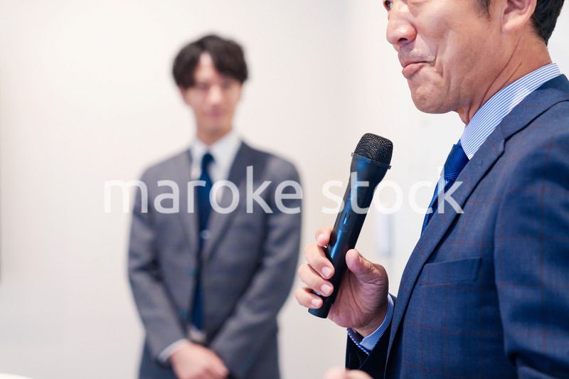 マイクを使って演説をする中年の男性