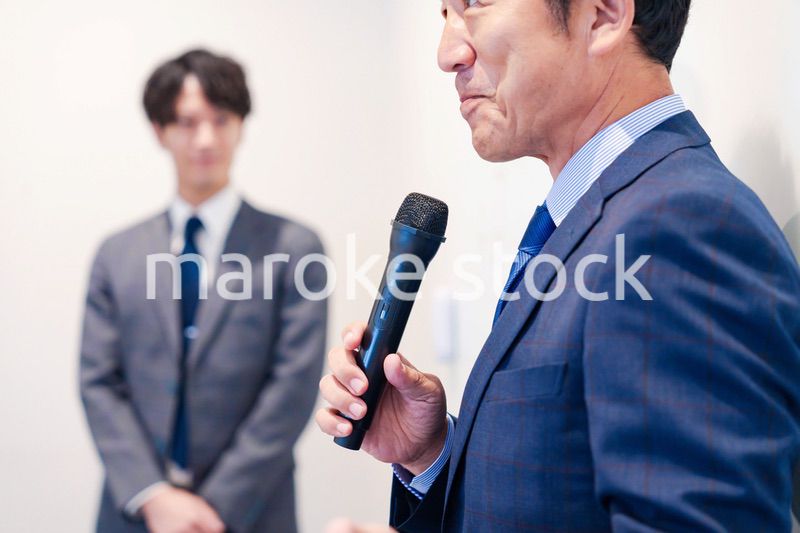 マイクを使って演説をする中年の男性
