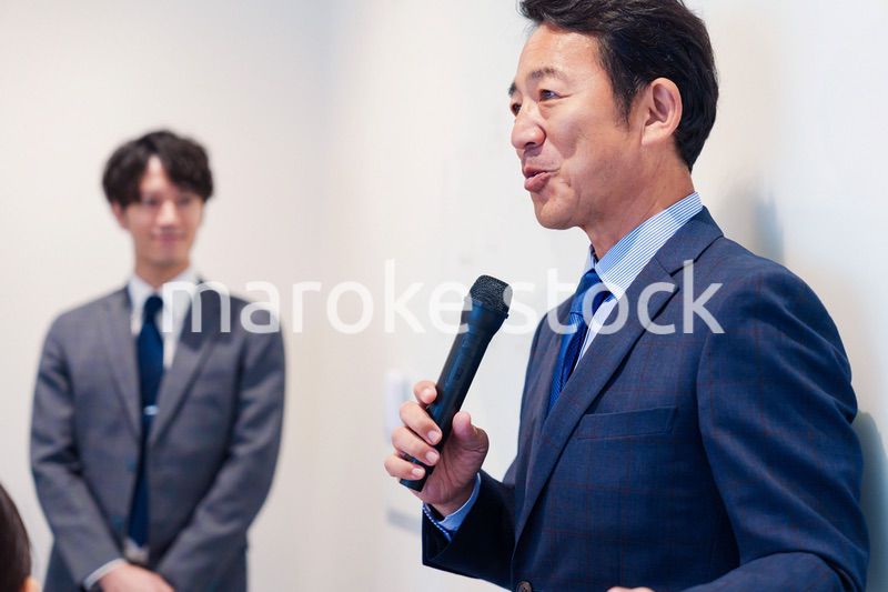 マイクを使って演説をする中年の男性