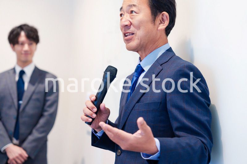 マイクを使って演説をする中年の男性