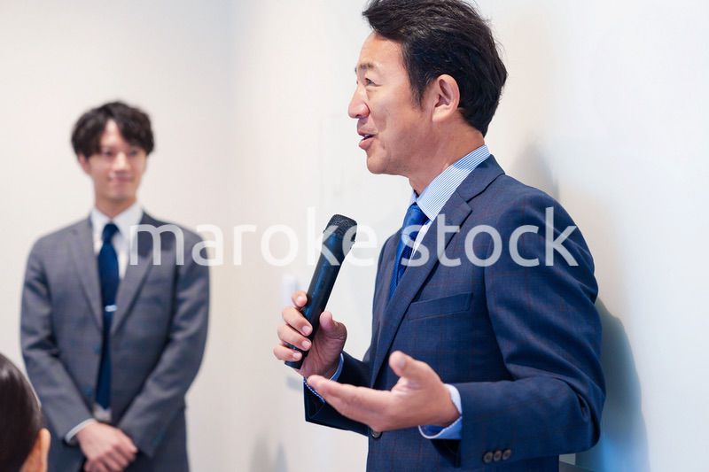 マイクを使って演説をする中年の男性