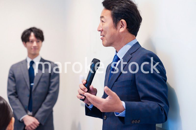 マイクを使って演説をする中年の男性