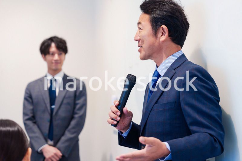 マイクを使って演説をする中年の男性