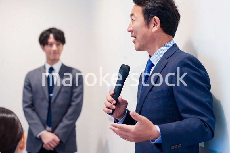 マイクを使って演説をする中年の男性