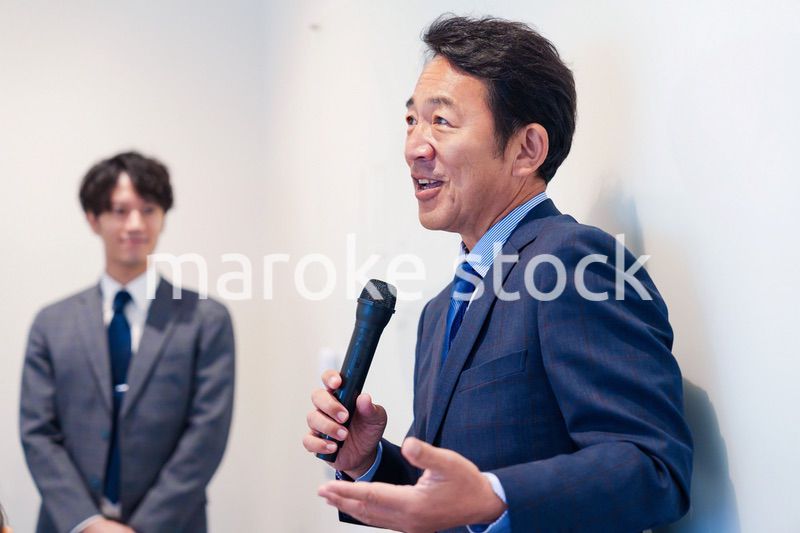 マイクを使って演説をする中年の男性