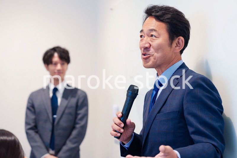 マイクを使って演説をする中年の男性