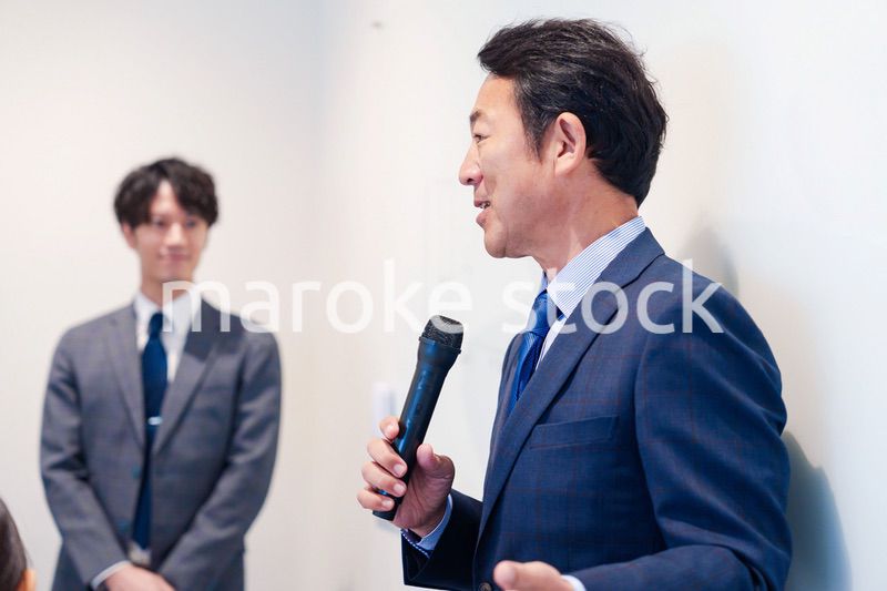 マイクを使って演説をする中年の男性