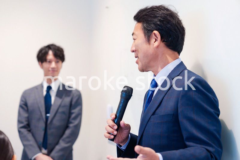 マイクを使って演説をする中年の男性