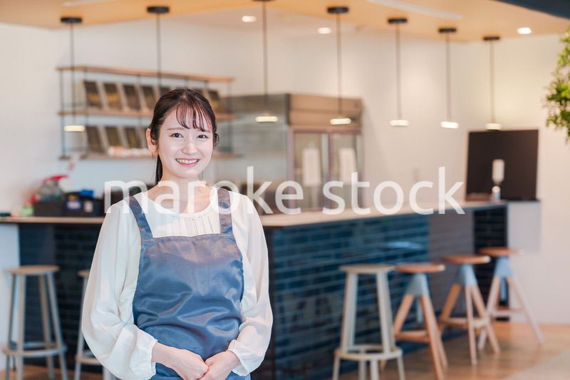 笑顔で働くカフェスタッフの女性