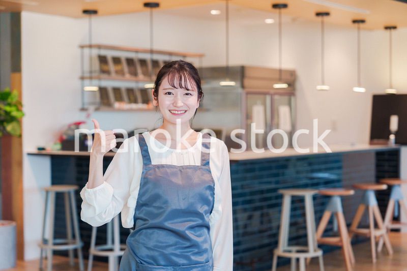 笑顔で働くカフェスタッフの女性