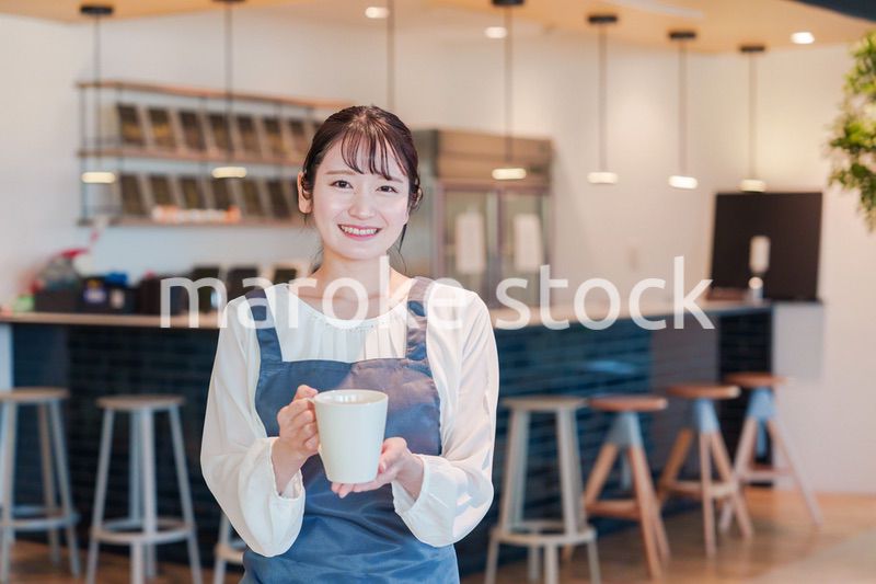 笑顔で働くカフェスタッフの女性