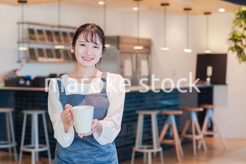 笑顔で働くカフェスタッフの女性