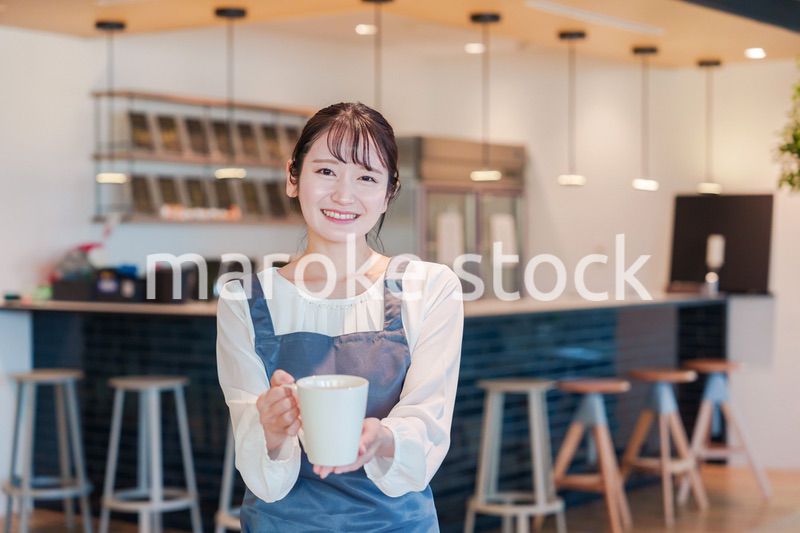 笑顔で働くカフェスタッフの女性