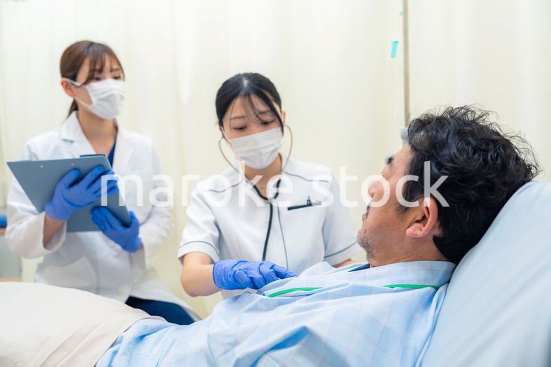 病棟で入院患者のバイタルチェックをする看護師の女性