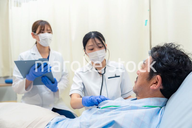 病棟で入院患者のバイタルチェックをする看護師の女性