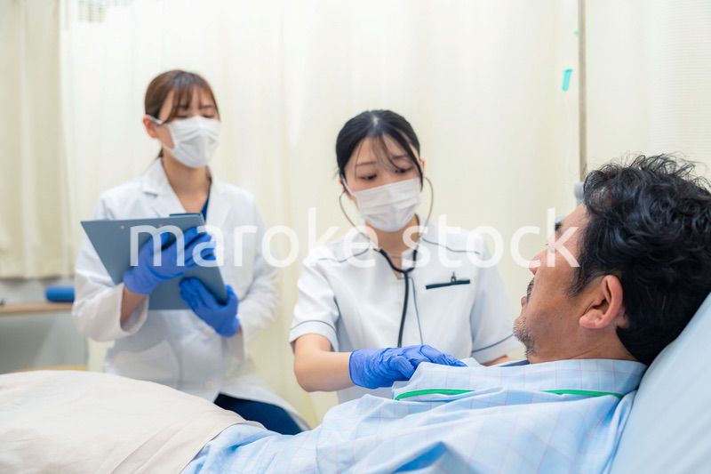 病棟で入院患者のバイタルチェックをする看護師の女性