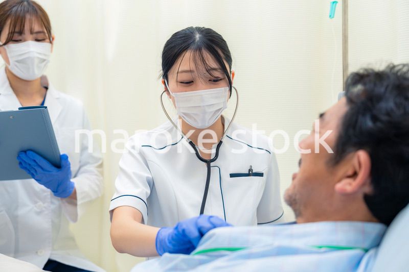 病棟で入院患者のバイタルチェックをする看護師の女性