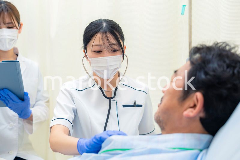 病棟で入院患者のバイタルチェックをする看護師の女性