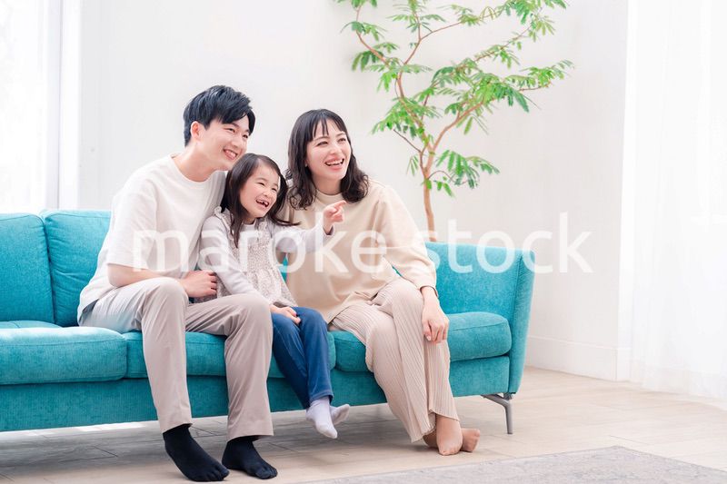 リビングでみんなでテレビを見るファミリー
