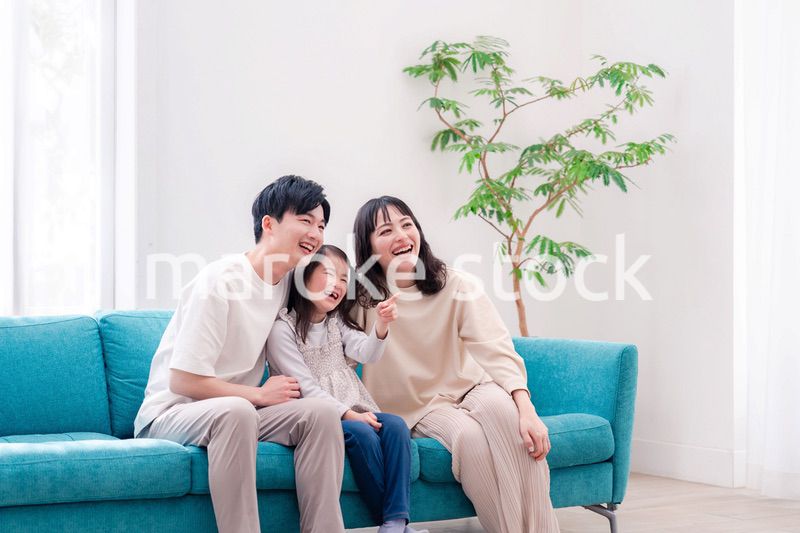 リビングでみんなでテレビを見るファミリー