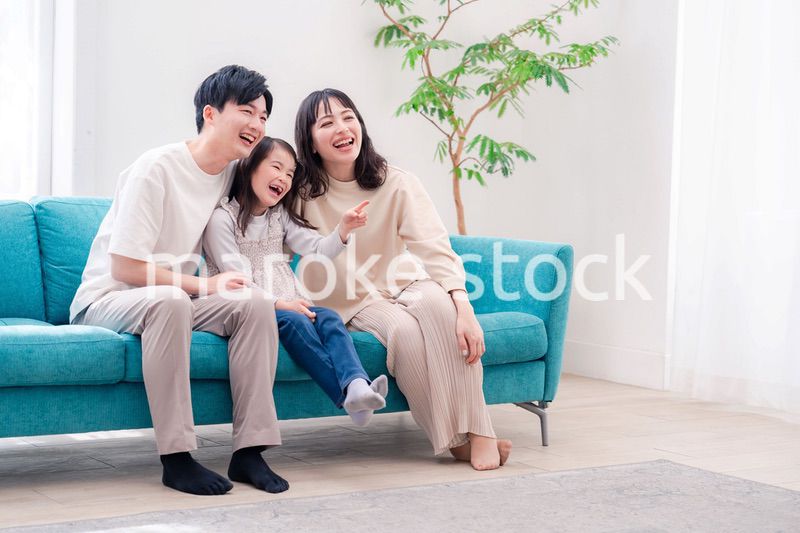 リビングでみんなでテレビを見るファミリー