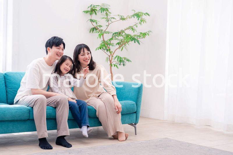 リビングでみんなでテレビを見るファミリー