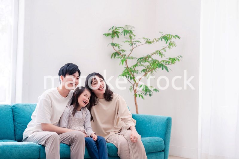 リビングでみんなでテレビを見るファミリー