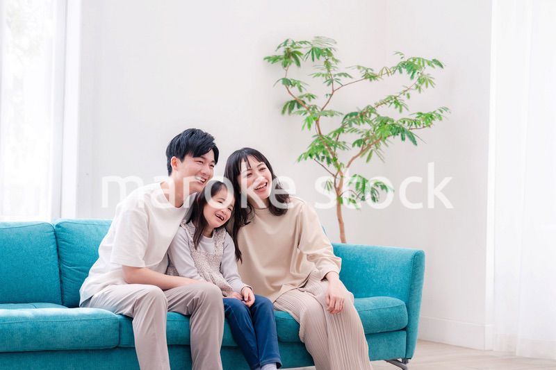 リビングでみんなでテレビを見るファミリー