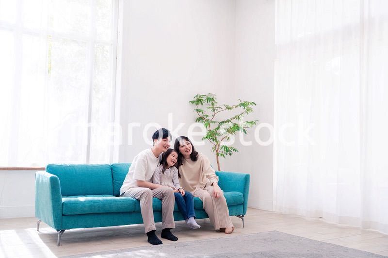 リビングでみんなでテレビを見るファミリー