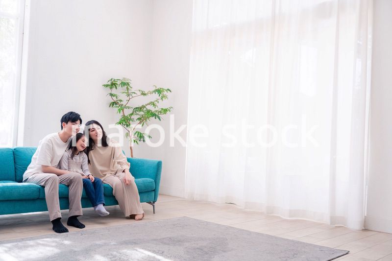 リビングでみんなでテレビを見るファミリー