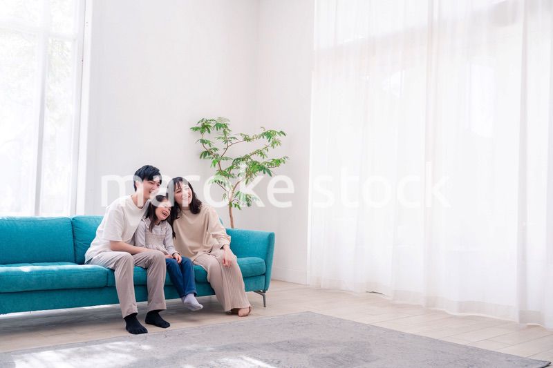 リビングでみんなでテレビを見るファミリー