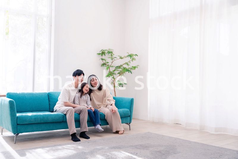 リビングでみんなでテレビを見るファミリー