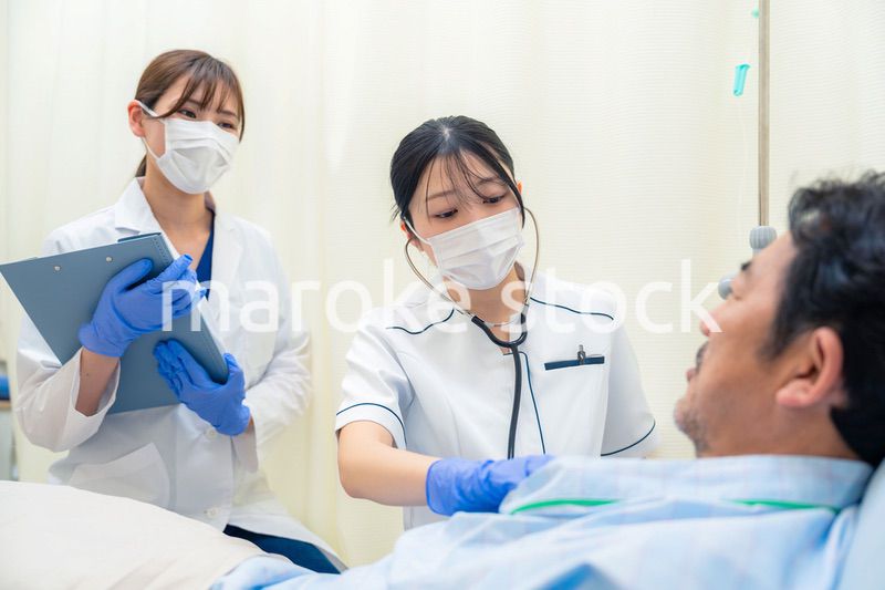 病棟で入院患者のバイタルチェックをする看護師の女性