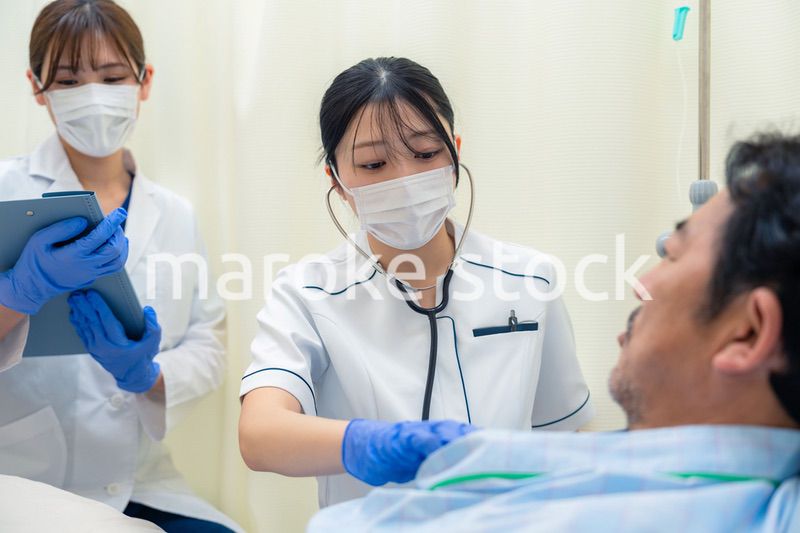 病棟で入院患者のバイタルチェックをする看護師の女性