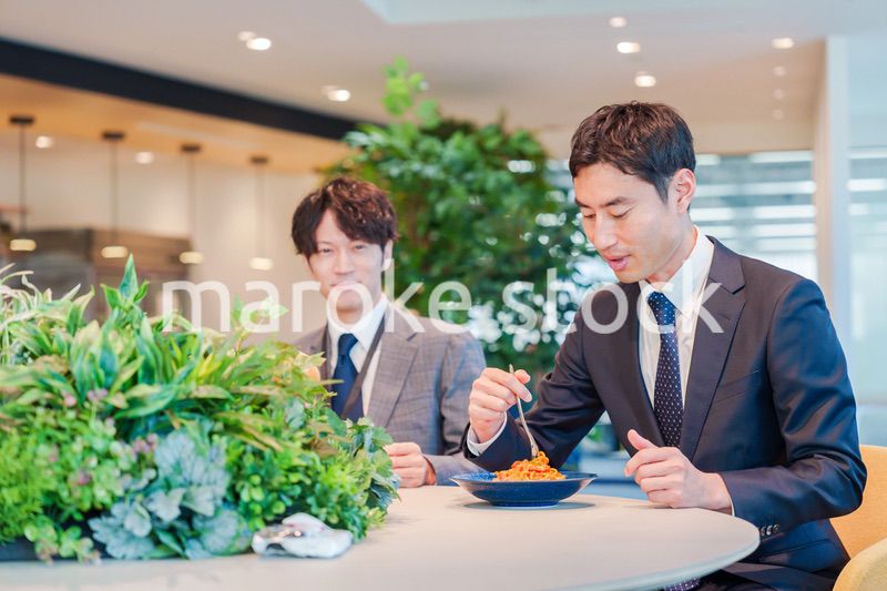 おしゃれなオフィスのカフェテリアでランチをするビジネスマン