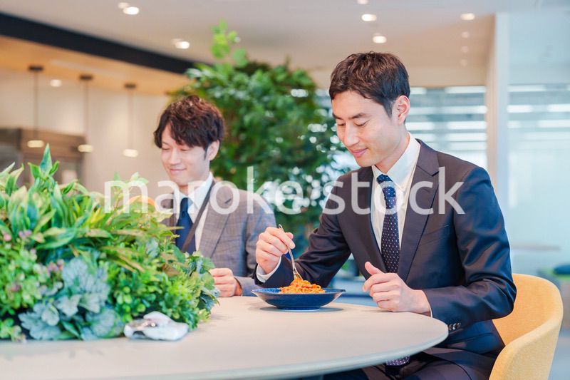 おしゃれなオフィスのカフェテリアでランチをするビジネスマン