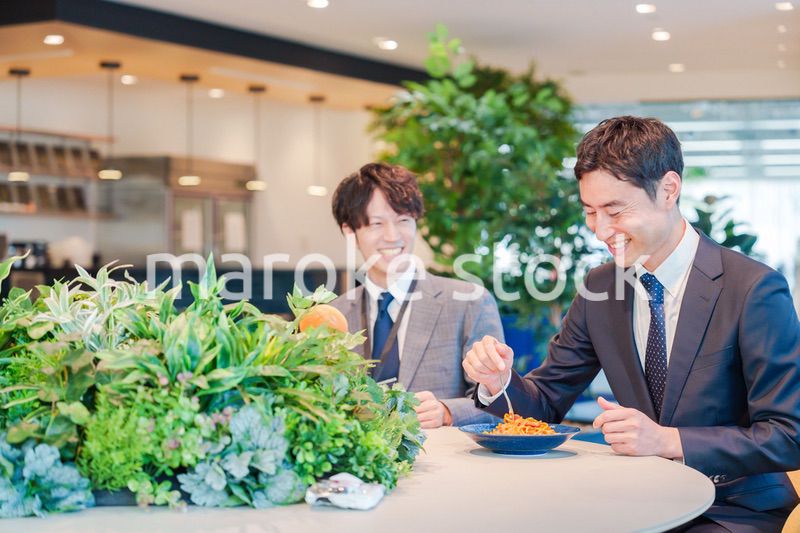 おしゃれなオフィスのカフェテリアでランチをするビジネスマン