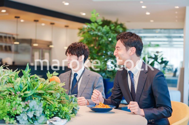 おしゃれなオフィスのカフェテリアでランチをするビジネスマン