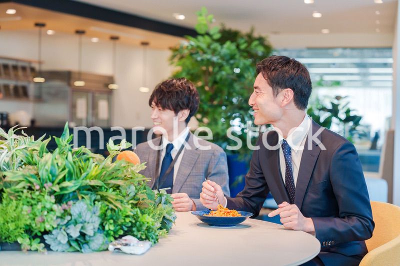 おしゃれなオフィスのカフェテリアでランチをするビジネスマン