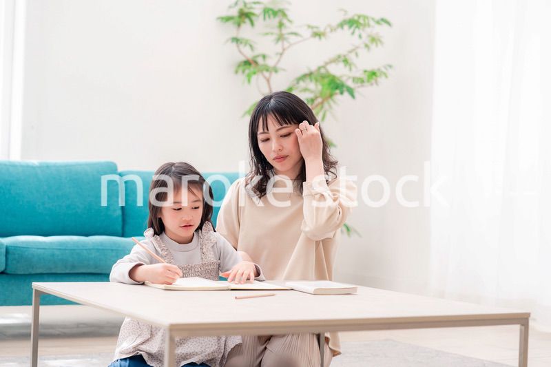 幼稚園児の女の子と一緒に勉強をするお母さん