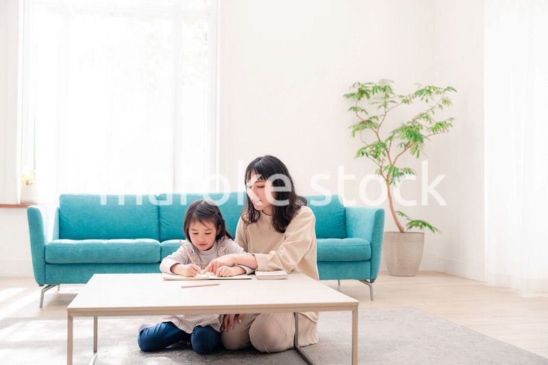 幼稚園児の女の子と一緒に勉強をするお母さん