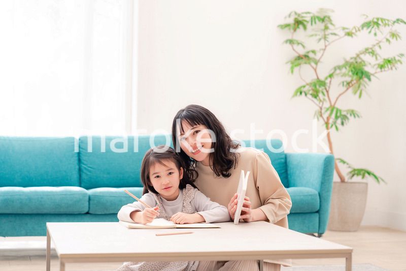 幼稚園児の女の子と一緒に勉強をするお母さん