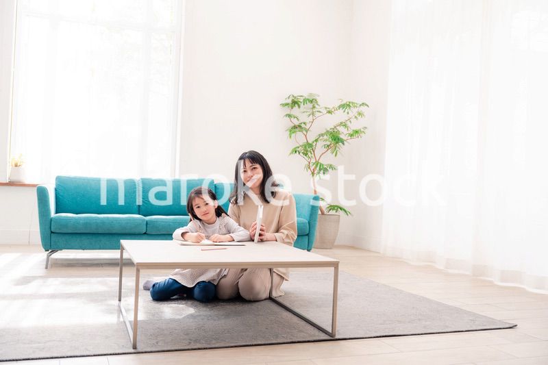 幼稚園児の女の子と一緒に勉強をするお母さん