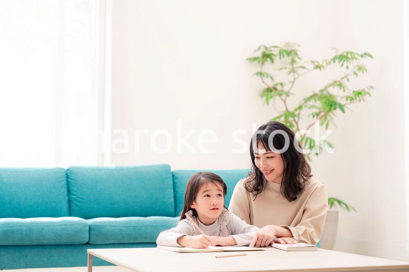 幼稚園児の女の子と一緒に勉強をするお母さん
