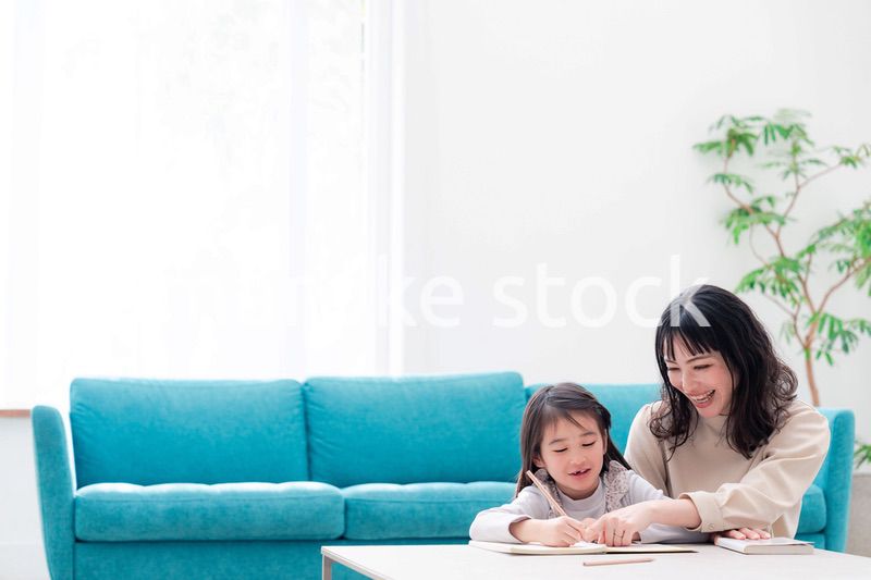 幼稚園児の女の子と一緒に勉強をするお母さん