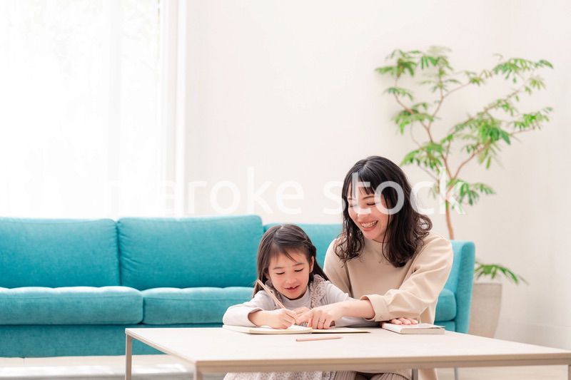 幼稚園児の女の子と一緒に勉強をするお母さん